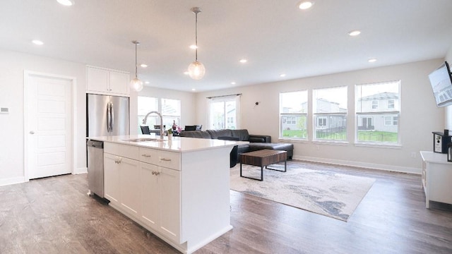 13333 W 180th St, Overland Park, KS 66013 - kitchen with stainless steel appliances, a sink, white cabinetry, wood finished floors, and open floor plan