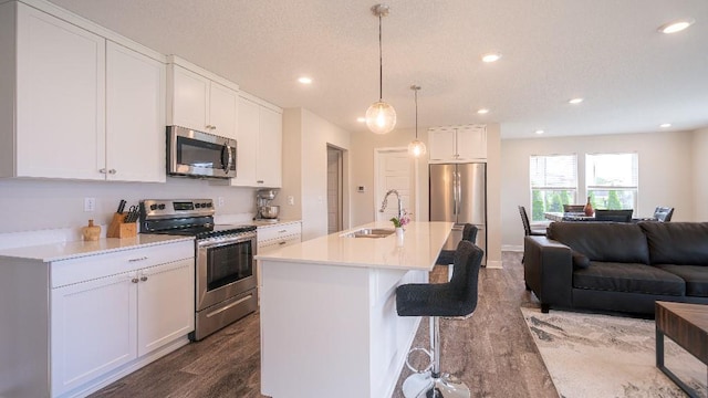 13333 W 180th St, Overland Park, KS 66013 - kitchen featuring appliances with stainless steel finishes, a sink, open floor plan, dark wood finished floors, and white cabinetry
