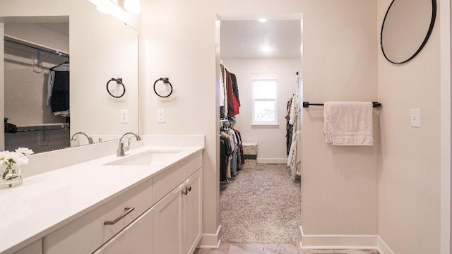 13333 W 180th St, Overland Park, KS 66013 - bathroom featuring baseboards, double vanity, and a walk in closet