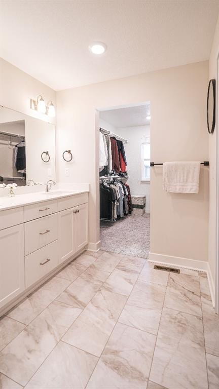 13333 W 180th St, Overland Park, KS 66013 - bathroom featuring double vanity, a spacious closet, baseboards, and recessed lighting