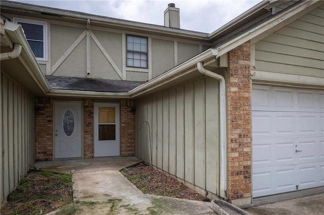 706 Cedar Dr Unit C, Warrensburg, MO 64093 - property entrance with an attached garage, a chimney, and brick siding