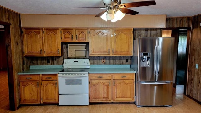 1045 Yale Rd, Mapleton, KS 66754 - kitchen with stainless steel fridge, white range with electric stovetop, light countertops, a textured ceiling, and brown cabinetry