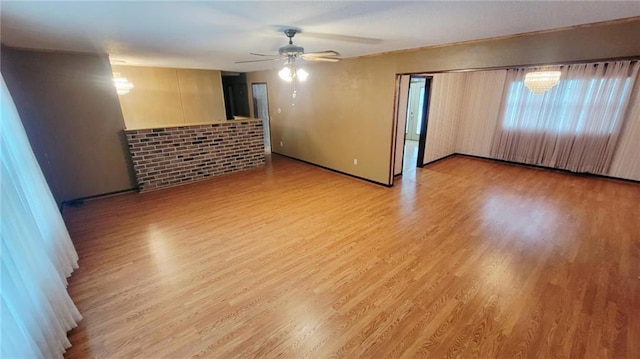 1045 Yale Rd, Mapleton, KS 66754 - empty room featuring ceiling fan, light wood-style floors, a brick fireplace, and baseboards