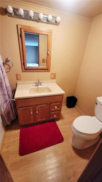 1045 Yale Rd, Mapleton, KS 66754 - bathroom featuring wood finished floors, toilet, vanity, ornamental molding, and baseboards
