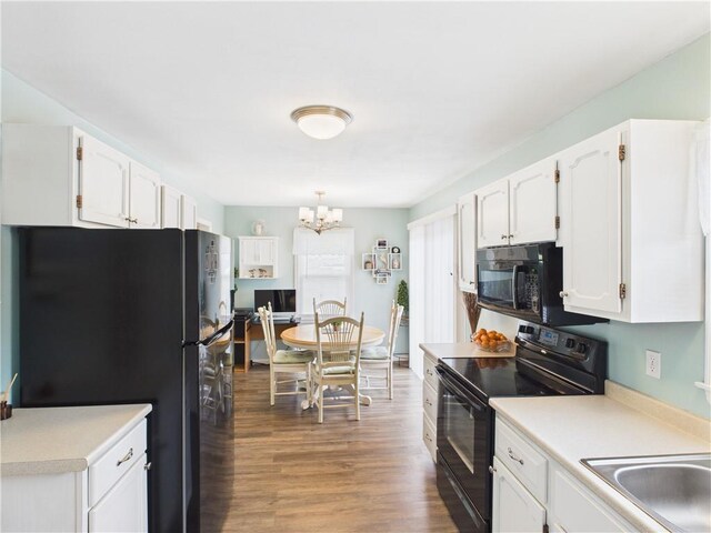 8101 E 133rd Ter, Grandview, MO 64030 - kitchen with black appliances, white cabinetry, a chandelier, and light countertops