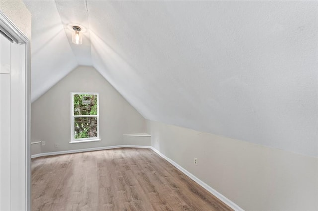 803 E College St, Independence, MO 64050 - bonus room featuring vaulted ceiling, wood finished floors, a textured ceiling, and baseboards