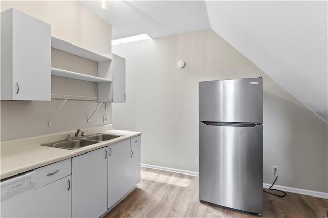 803 E College St, Independence, MO 64050 - kitchen featuring freestanding refrigerator, dishwasher, a sink, light wood-style flooring, and open shelves