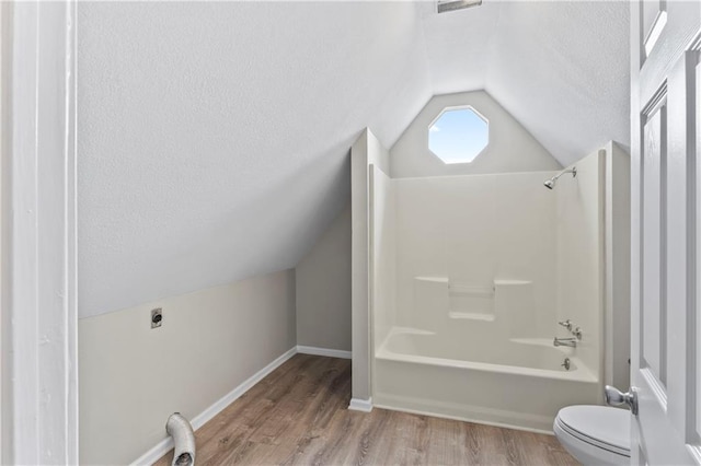 803 E College St, Independence, MO 64050 - bathroom featuring lofted ceiling, toilet, wood finished floors, shower / bath combination, and a textured ceiling