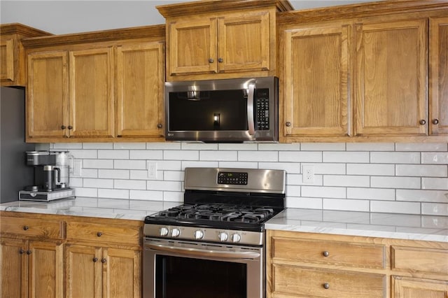 16910 Juniper Dr, Basehor, KS 66007 - kitchen featuring appliances with stainless steel finishes, brown cabinets, and decorative backsplash