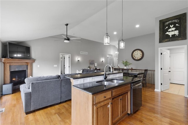 16910 Juniper Dr, Basehor, KS 66007 - kitchen with dishwasher, ceiling fan, a glass covered fireplace, vaulted ceiling, and light wood-style flooring