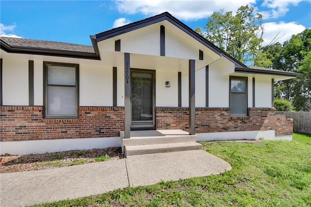 11704 E 76th Ter, Raytown, MO 64138 - view of front of property featuring brick siding, a front yard, and stucco siding