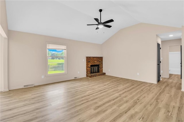 11704 E 76th Ter, Raytown, MO 64138 - unfurnished living room with lofted ceiling, a ceiling fan, light wood-style flooring, and a brick fireplace
