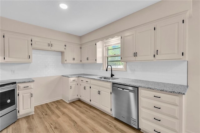 11704 E 76th Ter, Raytown, MO 64138 - kitchen featuring stainless steel appliances, a sink, light stone countertops, white cabinets, and light wood-style floors