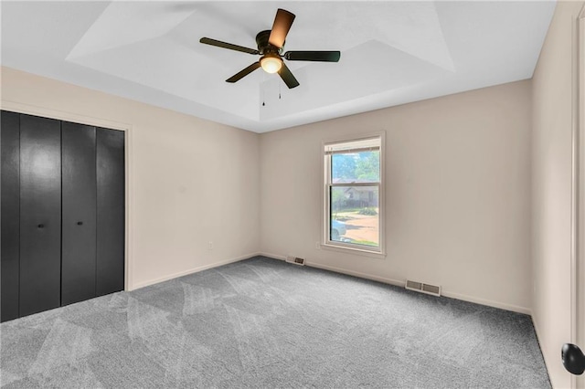 11704 E 76th Ter, Raytown, MO 64138 - unfurnished bedroom featuring a raised ceiling, carpet flooring, and baseboards