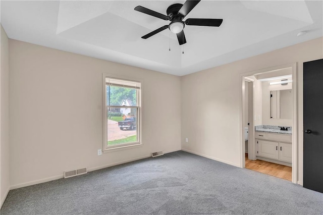 11704 E 76th Ter, Raytown, MO 64138 - unfurnished bedroom with light carpet, ensuite bathroom, baseboards, ceiling fan, and a sink