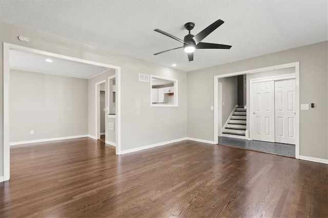 9741 Walnut St, Kansas City, MO 64114 - unfurnished living room featuring stairs, wood finished floors, a ceiling fan, and a textured ceiling