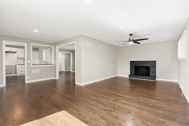 9741 Walnut St, Kansas City, MO 64114 - unfurnished living room with a ceiling fan, dark wood-style flooring, a fireplace with raised hearth, and recessed lighting