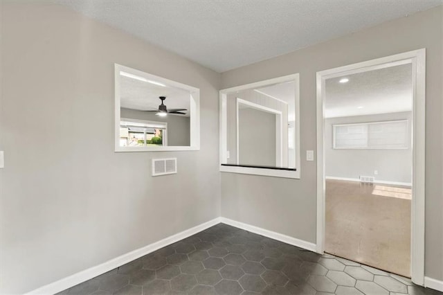 9741 Walnut St, Kansas City, MO 64114 - spare room featuring a ceiling fan, a textured ceiling, and dark tile patterned flooring