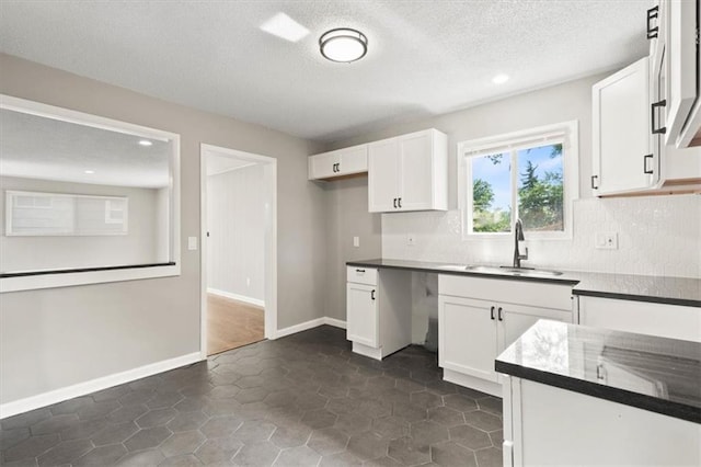 9741 Walnut St, Kansas City, MO 64114 - kitchen featuring backsplash, white cabinetry, recessed lighting, a textured ceiling, and dark countertops
