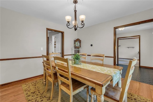 10124 Halsey St, Lenexa, KS 66215 - dining room featuring a chandelier, light wood-type flooring, and baseboards