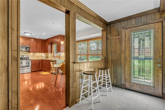 10124 Halsey St, Lenexa, KS 66215 - kitchen featuring stainless steel appliances, plenty of natural light, backsplash, wooden walls, and a sink