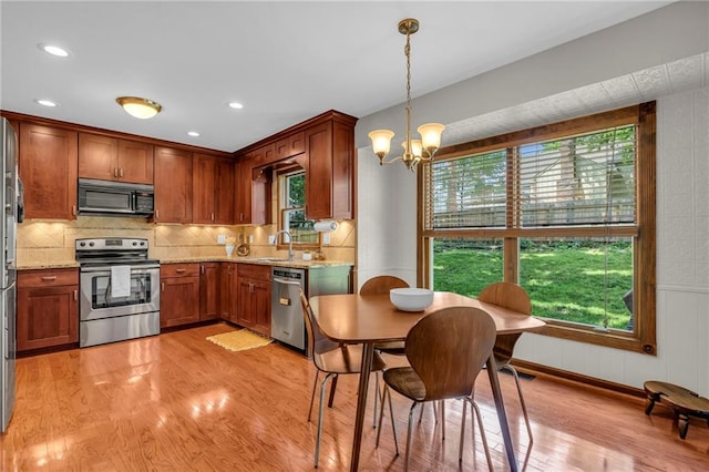 10124 Halsey St, Lenexa, KS 66215 - kitchen with stainless steel appliances, a chandelier, light wood-type flooring, healthy amount of natural light, and recessed lighting