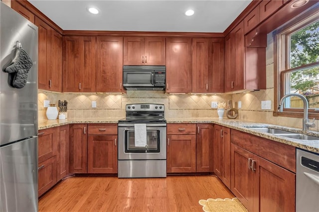10124 Halsey St, Lenexa, KS 66215 - kitchen with stainless steel appliances, a sink, light wood-style floors, light stone counters, and recessed lighting