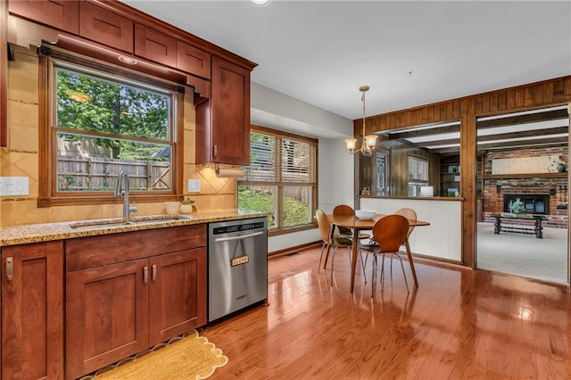 10124 Halsey St, Lenexa, KS 66215 - kitchen featuring stainless steel dishwasher, a sink, light wood finished floors, a chandelier, and decorative light fixtures