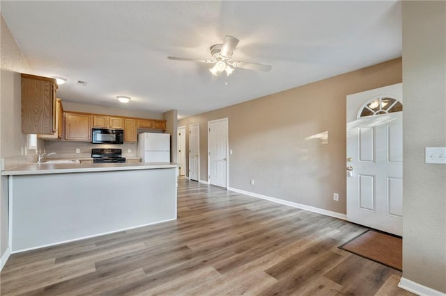 739 S Cypress St, Ottawa, KS 66067 - kitchen featuring black microwave, freestanding refrigerator, stove, a ceiling fan, and wood finished floors