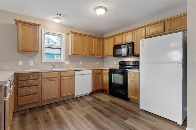 739 S Cypress St, Ottawa, KS 66067 - kitchen featuring black appliances, light countertops, and wood finished floors