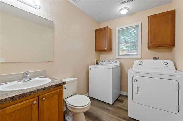 739 S Cypress St, Ottawa, KS 66067 - bathroom featuring washing machine and clothes dryer, vanity, and wood finished floors