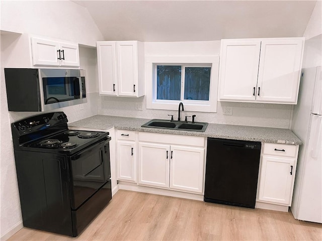 8633 N Main St, Kansas City, MO 64155 - kitchen with black appliances, a sink, light wood-style flooring, white cabinets, and vaulted ceiling
