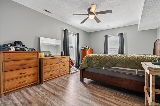 106 Saratoga St, Excelsior Springs, MO 64024 - bedroom with wood finished floors, a textured ceiling, multiple windows, and a ceiling fan