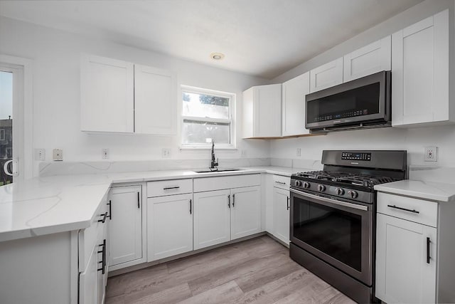 12655 S Clinton St, Olathe, KS 66061 - kitchen with stainless steel microwave, range with gas cooktop, a sink, light stone counters, and white cabinets