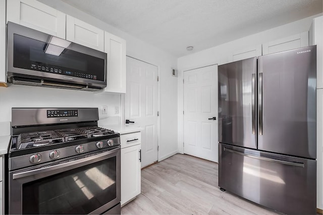 12655 S Clinton St, Olathe, KS 66061 - kitchen featuring stainless steel appliances, light countertops, white cabinetry, and light wood finished floors