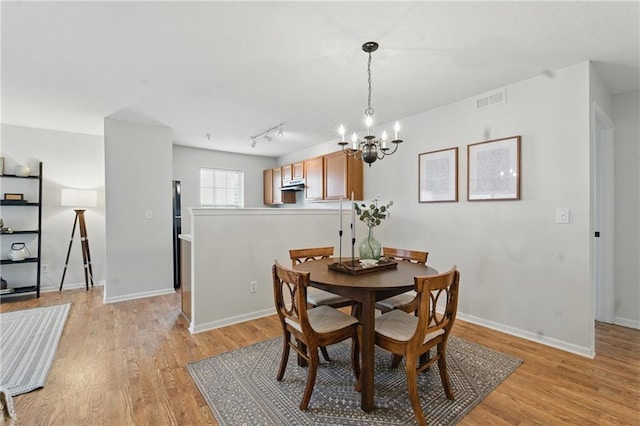 5610 NE 80th Ter Unit 1D, Kansas City, MO 64119 - dining area with a chandelier, light wood-style floors, and baseboards