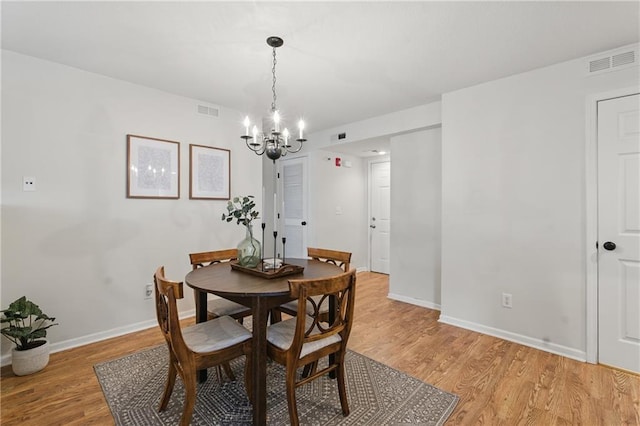 5610 NE 80th Ter Unit 1D, Kansas City, MO 64119 - dining room with a chandelier, light wood finished floors, and baseboards