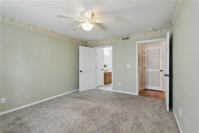 5610 NE 80th Ter Unit 1D, Kansas City, MO 64119 - unfurnished bedroom with light colored carpet, baseboards, ensuite bathroom, and ceiling fan