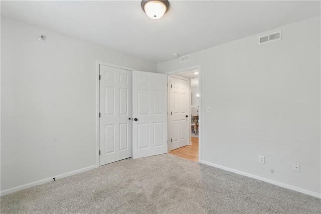 5610 NE 80th Ter Unit 1D, Kansas City, MO 64119 - unfurnished bedroom featuring light carpet, baseboards, and a closet