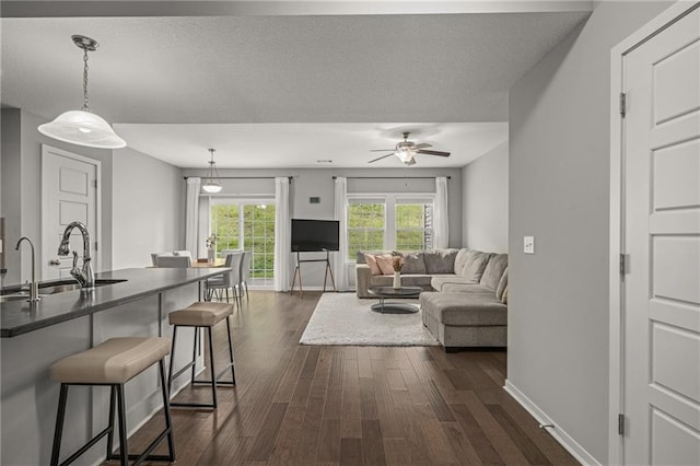 16059 Fontana St Unit 204, Overland Park, KS 66085 - living room with dark wood finished floors, ceiling fan, baseboards, and a textured ceiling