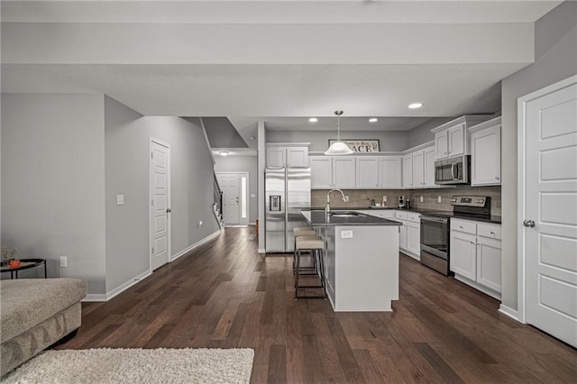16059 Fontana St Unit 204, Overland Park, KS 66085 - kitchen with stainless steel appliances, a kitchen breakfast bar, open floor plan, white cabinetry, and a kitchen island with sink