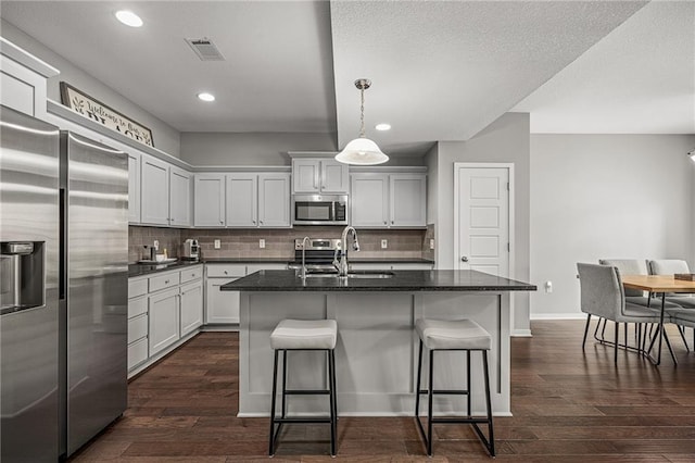 16059 Fontana St Unit 204, Overland Park, KS 66085 - kitchen featuring appliances with stainless steel finishes, a sink, a breakfast bar, backsplash, and recessed lighting