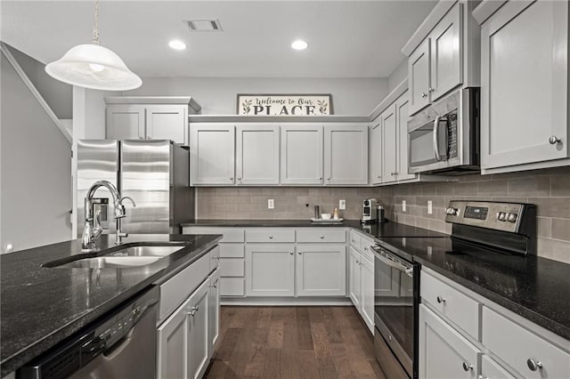 16059 Fontana St Unit 204, Overland Park, KS 66085 - kitchen featuring appliances with stainless steel finishes, a sink, dark wood-type flooring, backsplash, and dark stone counters