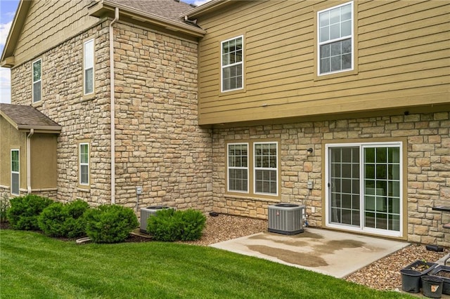 16059 Fontana St Unit 204, Overland Park, KS 66085 - back of property with stone siding, central air condition unit, a yard, and a patio area