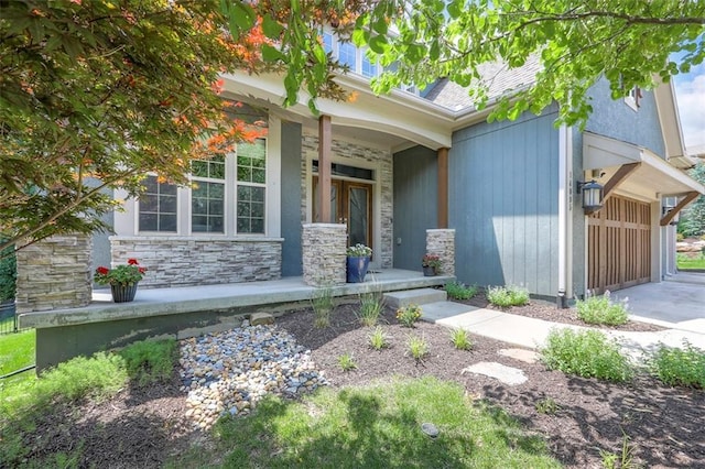 14095 NW 60th Ct, Parkville, MO 64152 - entrance to property featuring covered porch, stone siding, a garage, and concrete driveway