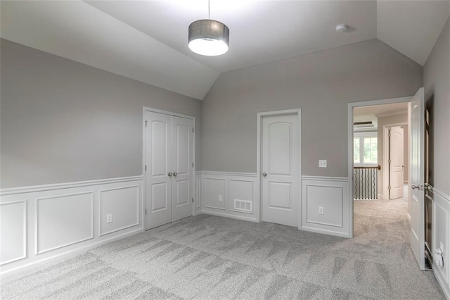 14095 NW 60th Ct, Parkville, MO 64152 - unfurnished bedroom with lofted ceiling, wainscoting, carpet floors, a decorative wall, and a wall mounted air conditioner