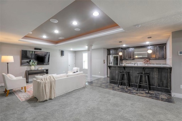 14095 NW 60th Ct, Parkville, MO 64152 - carpeted living area with decorative columns, a tray ceiling, bar with sink, and recessed lighting