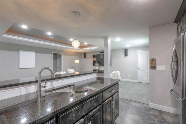 14095 NW 60th Ct, Parkville, MO 64152 - kitchen with freestanding refrigerator, a tray ceiling, recessed lighting, dark stone counters, and decorative light fixtures