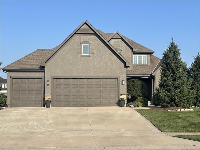 16488 S Summertree Ln, Olathe, KS 66062 - view of front facade featuring stucco siding, a garage, concrete driveway, and a shingled roof
