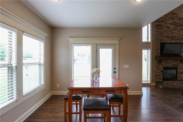 16488 S Summertree Ln, Olathe, KS 66062 - dining room featuring dark wood finished floors and a stone fireplace